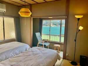a bedroom with a bed and a view of the water at 海峡別荘 in Shimonoseki
