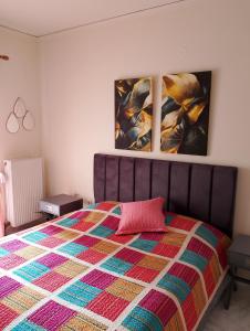 a bedroom with a bed and two paintings on the wall at home2024 in Alexandroupoli