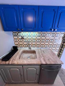 a kitchen with blue cabinets and a sink at Retro House with Garden in Anopoli in Thessaloniki