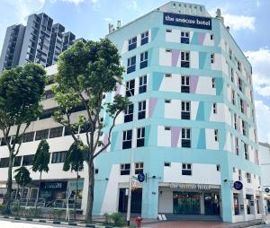 新加坡的住宿－The Snooze Hotel at Bugis，城市街道上的一座蓝白色建筑