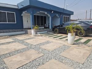 een auto geparkeerd voor een blauw huis bij Blueberry suite 1 in Accra