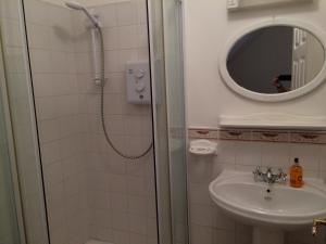 a bathroom with a shower and a sink and a mirror at Heart of Kinsale in Kinsale +27 photos