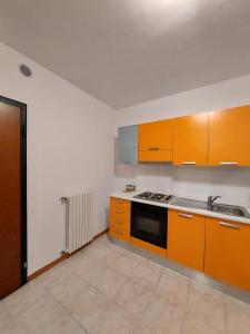 uma cozinha com armários laranja e um forno com placa de fogão em Meridian 45 A3 em Peschiera del Garda