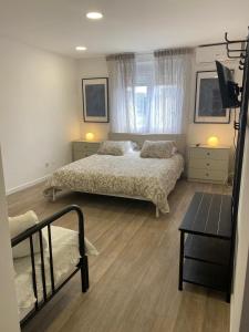 a bedroom with two beds and a television in it at Mata Beach Caparica in Costa da Caparica