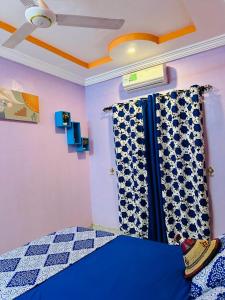 a bedroom with a blue bed and a curtain at Passion housse service in Ouagadougou