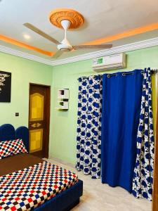 a room with a bed and a ceiling fan at Passion housse service in Ouagadougou