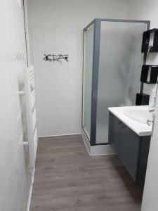 ein weißes Badezimmer mit einem Waschbecken und einem Spiegel in der Unterkunft Maison tout confort à Saint-Michel-Chef-Chef in Saint-Michel-Chef-Chef