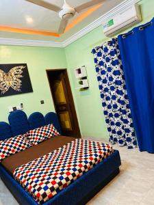 Passion housse service في واغادوغو: غرفة نوم بسرير وكراسي زرقاء وستائر زرقاء