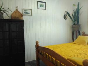 una camera da letto con un letto e un piumone giallo di La petite case jaune , jaccuzi pierre à 3 min à pied du bassin Manapany, vue mer a Saint-Joseph