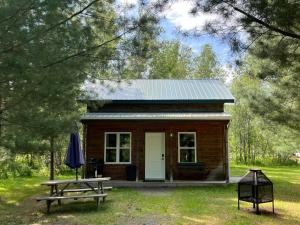 a small cabin with a picnic table and an umbrella at Chalets du Domaine Yamaska in Bromont