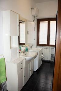 bagno bianco con lavandino e servizi igienici di Centra House - Big Gardened Flat Near Rome a Velletri