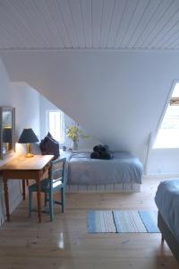 a bedroom with a bed and a desk and a table at Rosenhøj Bed and Breakfast in Svendborg