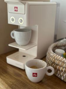 una cafetera con una taza de café sobre una mesa en Èlia Luxury Rooms, en Areopoli