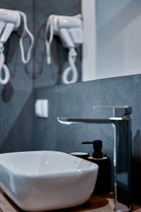 a white sink in a bathroom with a faucet at Apartament Sztuk Pięknych 10 in Piła +18 photos