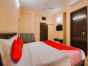Habitación de hotel con cama con almohadas rojas en OYO R.J.international en Pedda Ambarpet