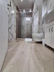 een badkamer met een douche, een bad en een wastafel bij Relax Lux apartment Nis in Niš