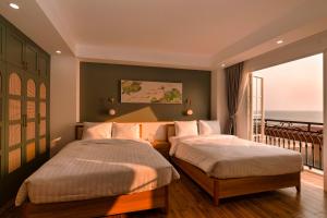 2 łóżka w pokoju z balkonem w obiekcie Lotus Home Hillside w Duong Dong