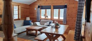 ein Wohnzimmer mit einem Sofa und einem Tisch in der Unterkunft B&B Camp Ängra in Kårböle