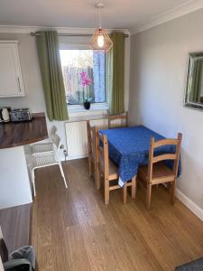 a dining room with a blue table and chairs at Dunfermline Home with Free Parking Near Amazon & M90 in Dunfermline
