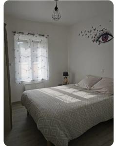 a bedroom with a bed with an eye on the wall at La petite maison in Monthermé