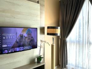 einen Flachbild-TV an einer Wand neben einem Fenster in der Unterkunft Themework Homestay@Cameron Highlands in Cameron Highlands