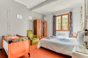 um quarto com uma cama e uma cadeira em Le Grappillon em Fitou