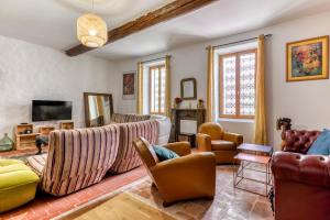 uma sala de estar com sofás e uma televisão em Le Grappillon em Fitou