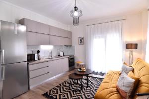 a living room with a couch and a kitchen at Antoine Apartment in Néa Péramos