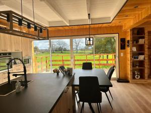 een keuken met een tafel en stoelen en een groot raam bij Les 5 thèmes in Antoigny