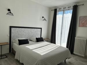 a bedroom with a large bed and a window at la porte medievale in Carcassonne