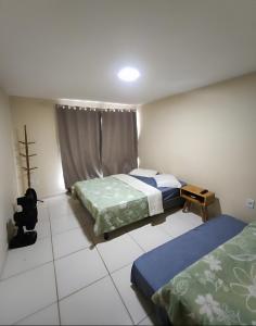 a bedroom with two beds and a window at Casa Duplex Arraial do Cabo 30 metros do Mar in Arraial do Cabo
