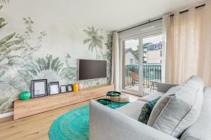 uma sala de estar com um sofá e uma televisão de ecrã plano em Fourcats Family em Chennevières-sur-Marne