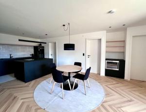 a kitchen and dining room with a table and chairs at Luxusappartement hôamele - Ferienwohnung mit Genuss in Alberschwende