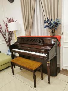 - un piano dans un salon avec un vase de fleurs dans l'établissement Deli Villa, à Muar
