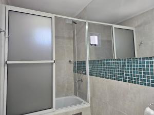 コリエンテスにあるCORRIENTES Apartamento con cochera autoのバスルーム(ガラスドア付きのシャワー付)