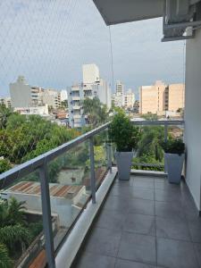 balcón con macetas y vistas a la ciudad en CORRIENTES Apartamento con cochera auto en Corrientes