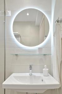 a bathroom with a white sink and a mirror at Evas Rooms in Nei Poroi
