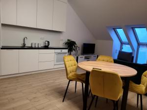 cocina y comedor con mesa y sillas en Apartament Dolina Baryczy Milicz, en Milicz