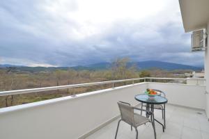 Un balcón con mesa y sillas y una vista. en Evas Rooms, en Neoi Poroi