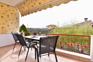 a table and chairs on a balcony with a view at Antoine Apartment in Nea Peramos