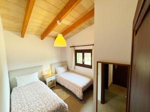 een kleine kamer met 2 bedden en een raam bij Maricel in Cala Ratjada