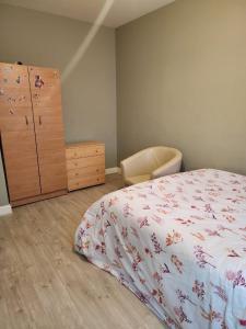 1 dormitorio con 1 cama, vestidor y silla en SEYI en Hatch End
