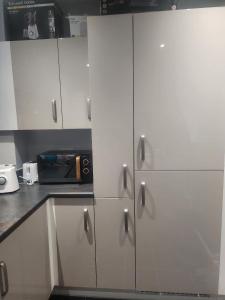 a kitchen with white cabinets and a counter top at SEYI in Hatch End