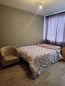 1 dormitorio con 1 cama, 1 silla y 1 ventana en SEYI en Hatch End