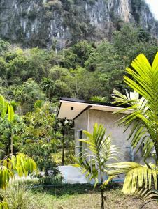 uma pequena casa no meio de uma montanha em บ้านเล็กในป่าใหญ่โฮมสเตย์ กงหรา พัทลุง 