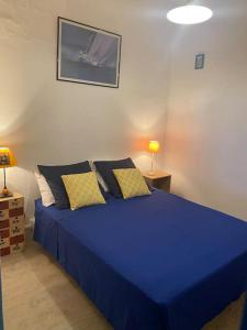 uma cama azul com almofadas num quarto em L'Andalou - Appt 6 personnes proche de la plage em Peyriac-de-Mer