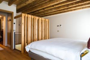 una camera con letto bianco e soffitti in legno di PALMANOVA SUITE HOME a Palmanova