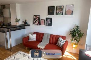 un soggiorno con divano rosso e tavolo di Stylish One Bedroom Apartment By Movida Property Group Short Lets & Serviced Accommodation Leeds a Leeds