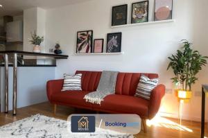 una sala de estar con un sofá rojo en una habitación en Stylish One Bedroom Apartment By Movida Property Group Short Lets & Serviced Accommodation Leeds en Leeds