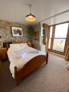 Tempat tidur dalam kamar di HUER'S WATCH a beautifully presented PRIVATE APARTMENT with far reaching VIEWS Over ST IVES HARBOUR and BAY and FREE ONSITE PARKING for LARGER GROUPS book along with our Connecting TWO SISTER APARTMENTS